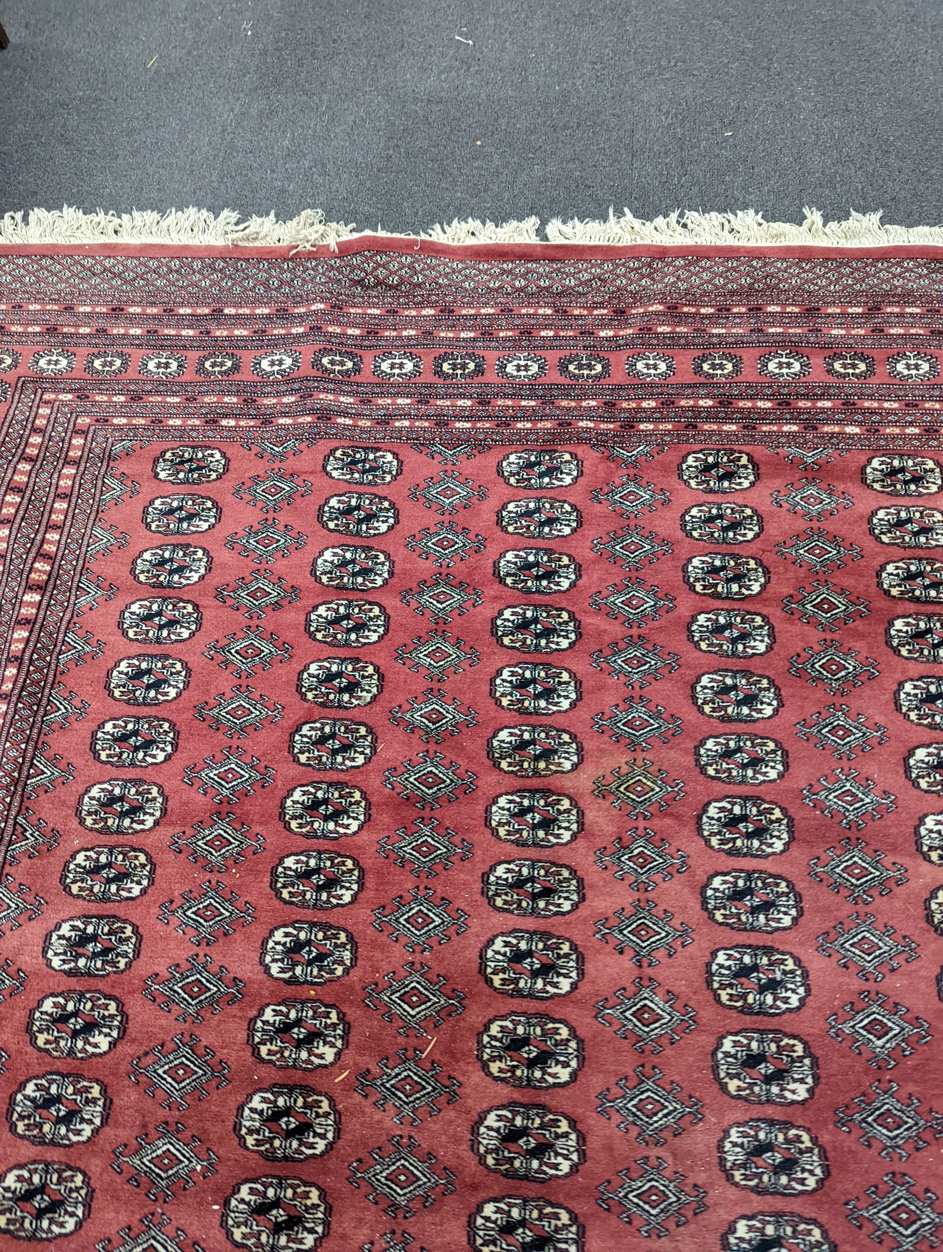 A Bokhara burgundy ground carpet, 360 x 276cm
